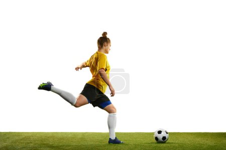 Foto de Winning goal. Young professional female football player in motion, training, playing football, soccer isolated over white background. Concept of sport, action, motion, goals, competition, hobby, ad. - Imagen libre de derechos