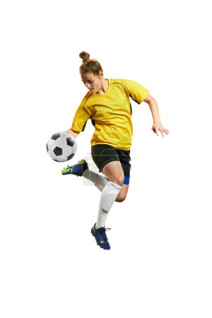 Photo for Young professional female football player in motion, playing football, soccer, hitting ball in a jump isolated over white background. Concept of sport, action, motion, goals, competition, hobby, ad. - Royalty Free Image
