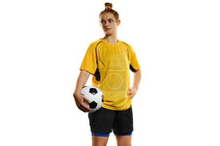 Foto de Young woman, professional female football, soccer player in yellow uniform posing with ball isolated over white studio background. Motivation. Concept of sport, action, competition, hobby, ad. - Imagen libre de derechos