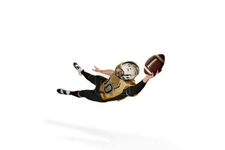 Foto de Catching ball in a jump. Man, professional american football player in motion, training over white studio background. Concept of sport, movement, achievements, competition, hobby, action - Imagen libre de derechos