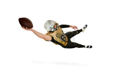 Téléchargez les photos : Man, american football player in motion, training, catching ball jumping over white studio background. Professional sportsman. Concept of sport, movement, achievements, competition. Copy space for ad - en image libre de droit
