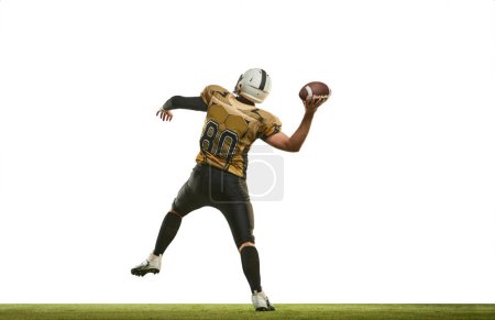 Téléchargez les photos : Throwing ball. Man, american football player in uniform playing, training over white studio background. Concept of sport, movement, achievements, competition, hobby. Copy space for ad - en image libre de droit