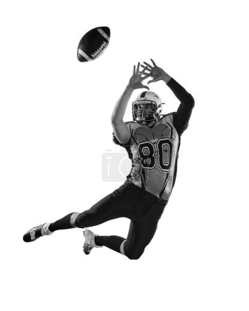 Foto de Black and white photo. Man, professional american football player in motion, training, catching ball over white studio background. Concept of sport, movement, achievements, competition, hobby - Imagen libre de derechos