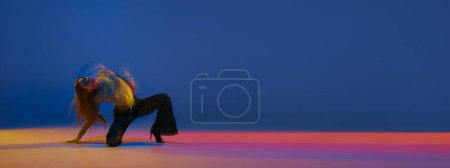 Téléchargez les photos : Portrait of young girl dancing heels dance over blue background in neon light with mixed lights. Banner, flyer. Concept of dance lifestyle, modern style, contemporary, youth culture, self-expression - en image libre de droit