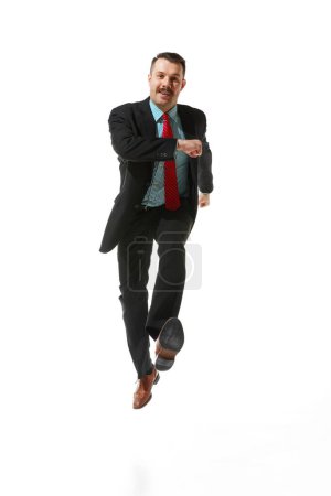 Foto de Front view. Businessman in a suit with positive mood walking to work over white studio background. On way to goal. Concept of business, career development, ambitions, strategy. Copy space for ad - Imagen libre de derechos