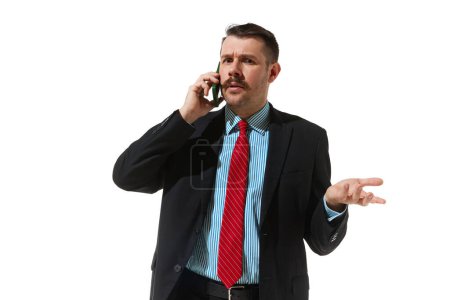 Photo for Businessman in a suit talking on phone with questioning face over white studio background. Misunderstanding. Concept of business, career development, ambitions, innovative strategy. Copy space for ad - Royalty Free Image