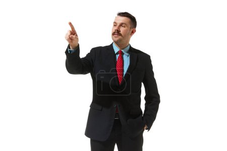 Foto de Businessman in a suit pointing with finger over white studio background. Checking project. Concept of business, career development, ambitions, innovative strategy. Copy space for ad - Imagen libre de derechos