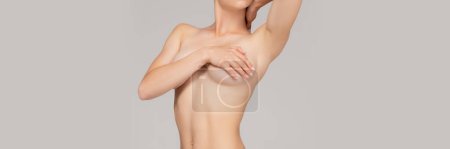 Photo for Cropped image of slim female body over grey studio background. Woman covering breast with hand. Female health care. Concept of body and skin care, health, wellness. Banner, flyer. Copy space for ad - Royalty Free Image