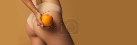 Photo for Cropped image of slim smooth female legs, buttocks with orange over light brown background. Anti-cellulite care. Concept of body, skin care, fitness, health, wellness. Banner, flyer. Copy space for ad - Royalty Free Image