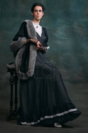 Photo for Femininity. Beautiful woman in image of Anna Karenina over vintage dark green background. Concept of literature character, history, retro style, comparison of eras, old-fashioned, emotions - Royalty Free Image