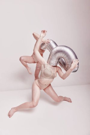 Photo for Hidden thoughts. Creative photography with two young girls posing in nude underwear over beige studio background. Concept of cringe, queer, art photography, weird people, creativity - Royalty Free Image