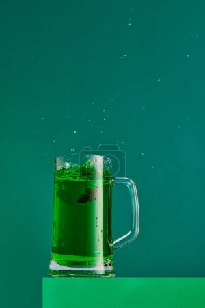 Foto de Extraordinary taste. Mug with green beer and anis isolated over green background. Concept of st patricks day celebration, brewery, traditions, alcohol drinks, taste, Irish holiday - Imagen libre de derechos