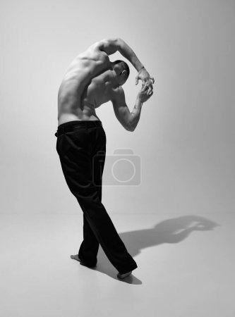 Téléchargez les photos : Relief. Black and white photography. Masculinity aesthetics. Young man posing shirtless. Muscular body shape. Concept of mens health and beauty, body and skin care, fitness. Body art - en image libre de droit
