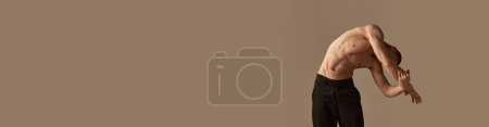 Foto de Retrato de joven pelirrojo guapo posando sin camisa en pantalones sobre fondo gris estudio. Forma muscular del cuerpo. Concepto de salud y belleza para hombre, cuidado corporal, fitness. Banner. Copiar espacio para anuncios, texto - Imagen libre de derechos