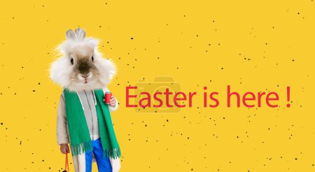 Foto de Coziness. Bunny head on human body in furry coat greeting with holiday. Creative design on yellow background. Happy Easter. Concept of celebration. Copy space for ad, text. Design for card - Imagen libre de derechos
