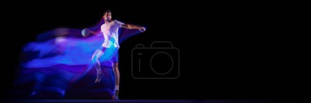 Photo for Young man, professional handball player in motion, playing over black background with mixed lights effect. Sport, motion, championship, sportive lifestyle concept. Banner, flyer. Copy space for ad - Royalty Free Image