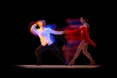 Foto de Talent. Beautiful young people, man and woman dancing tango, ballroom over black background with mixed neon lights. Concept of hobby, lifestyle, action, beauty of movements, emotions, fashion, art - Imagen libre de derechos