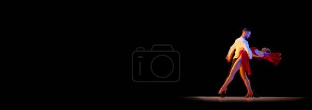 Photo for Young man and woman dancing tango, ballroom over black background with mixed neon lights. Concept of hobby, lifestyle, action, beauty of movements, emotions, fashion, art. Banner. Copy space for ad - Royalty Free Image
