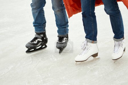 Foto de Imagen recortada de piernas masculinas y femeninas en patines, patinaje sobre pista de hielo. Fines de semana activos. Concepto de actividad lúdica, pasatiempo y deporte invernal, vacaciones, diversión, relación, emociones. - Imagen libre de derechos
