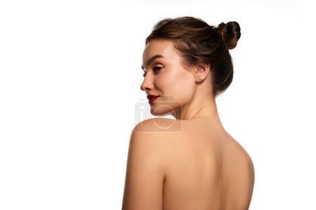 Téléchargez les photos : Side view portrait. Naked shoulders. One beautiful brunette girl posing against white studio background. Concept of natural beauty, youth, health, wellness, femininity, make-up - en image libre de droit
