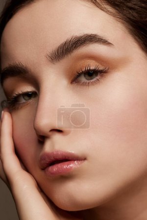 Téléchargez les photos : Purity and tenderness. Close-up portrait of young beautiful girl with shimmer eye shadow makeup. Well-kept healthy skin condition. Concept of natural beauty, skincare, cosmetology, cosmetics, health - en image libre de droit