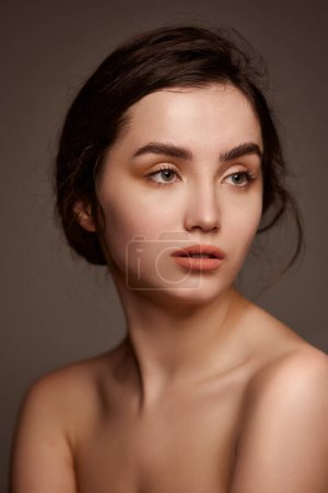 Photo for Purity and tenderness. Portrait of young beautiful girl with brown hair posing over dark grey studio background. Concept of natural beauty, skincare, cosmetology, plastic surgery, health - Royalty Free Image