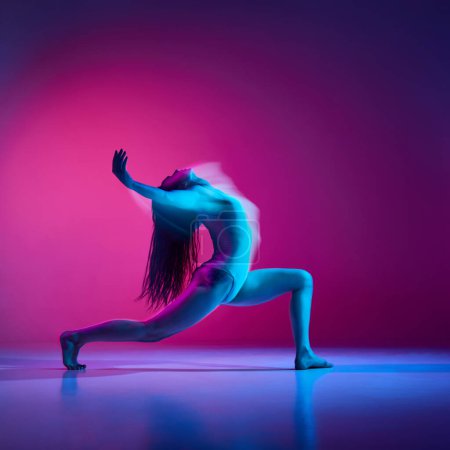 Téléchargez les photos : Jeune femme souple en body dansant sur fond de studio rose dégradé au néon avec lumières mixtes. Concept de danse contemporaine style, art, esthétique, passe-temps, style de vie créatif - en image libre de droit
