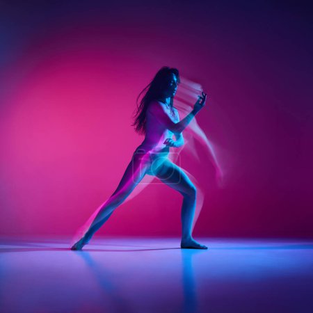 Téléchargez les photos : Des sentiments. Jeune femme dansant style de danse moderne sur fond de studio rose dégradé au néon avec des lumières mélangées. Concept de danse contemporaine style, art, esthétique, passe-temps, style de vie créatif - en image libre de droit