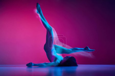 Téléchargez les photos : Portrait dynamique de jeune femme souple dansant contemp, danse freestyle sur fond de studio rose dégradé au néon avec lumières mixtes. Concept de danse contemporaine style, art, esthétique, créativité - en image libre de droit