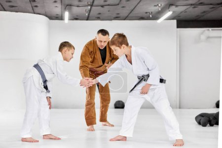 Photo for Greeting before fight session. Boys, children shaking hands, ready to train judo, jiu-jitsu exercises. Attentive coach. Concept of martial arts, combat sport, sport education, childhood, hobby - Royalty Free Image