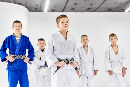 Foto de Portrait of boys, children in kimono. judo, jiu-jitsu athletes posing with serious facial expression. Concept of martial arts, combat sport, sport education, childhood, hobby - Imagen libre de derechos