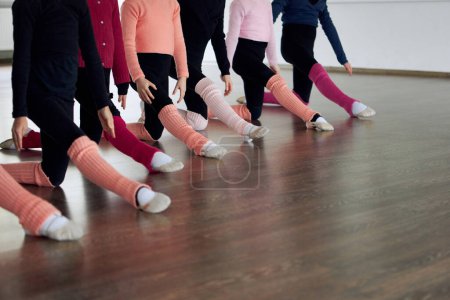 Photo for Cropped images of kids legs doing stretching exercises indoors. Gymnastics training. Concept of sportive lifestyle, childhood, education, health, professional sport. - Royalty Free Image