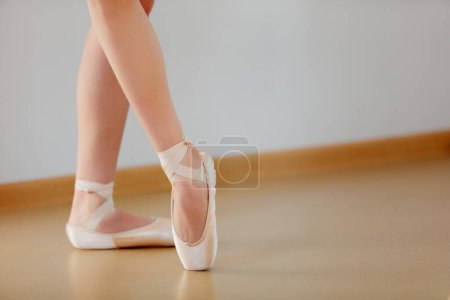 Téléchargez les photos : Image recadrée de jambes féminines debout sur la pointe dans une école de studio de ballet à l'intérieur. Artiste de ballet classique. Couleurs pastel tendres. Concept de ballet classique, danse art, éducation, beauté, chorégraphie - en image libre de droit