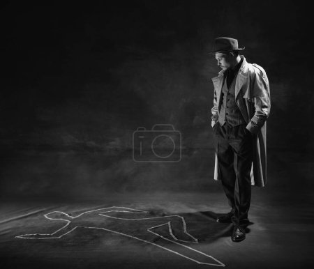 Téléchargez les photos : Black and white, noir photography. Man, detective in hat and trench coat looking on human drawn silhouette on floor. Murder investigation. Concept of occupation, character, history. Retro style - en image libre de droit