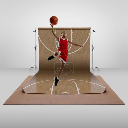 Photo for Slam dunk. Teen boy, professional basketball player in uniform, training, playing over sports playground background. Concept of art, healthy lifestyle, professional sport, hobby, power, strength - Royalty Free Image