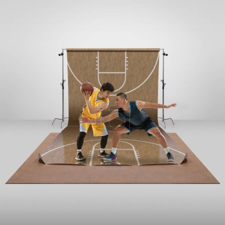 Téléchargez les photos : Competitive spirit. Young boys, profesisonal basketball players training, playing over sports playground background. Concept of art, healthy lifestyle, professional sport, hobby, power and strength - en image libre de droit