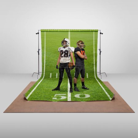 Téléchargez les photos : Champions. Two men, professional american football players in uniform posing over sports playground background. Concept of art, healthy lifestyle, professional sport, hobby, power and strength - en image libre de droit
