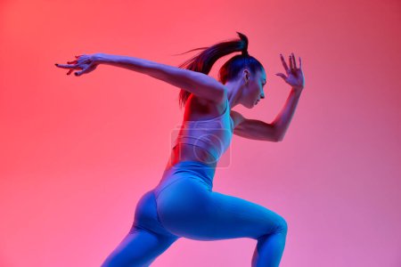 Téléchargez les photos : Speed. Dynamic image of young active girl, athlete, runner in motion, training over pink studio background in neon light. Concept of sportive lifestyle, health, endurance, action and motion. Ad - en image libre de droit