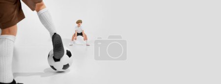 Photo for Little boys, children in retro style clothes playing football, having fun against grey studio background. Concept of game, childhood, friendship, activity, leisure time, retro style, fashion. Banner - Royalty Free Image
