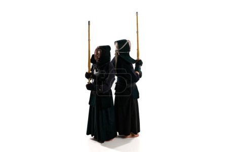 Photo for Top view. Back to back. Two men, professional kendo athletes in uniform posing shinai sword against white studio background. Concept of martial arts, sport, Japanese culture, action and motion - Royalty Free Image