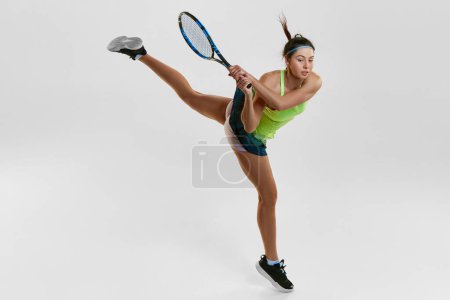 Foto de Fuerza y resistencia. Retrato de mujer joven, entrenando como jugadora de tenis profesional sobre fondo blanco. Concepto de deporte profesional, movimiento, salud, acción. Anuncio - Imagen libre de derechos