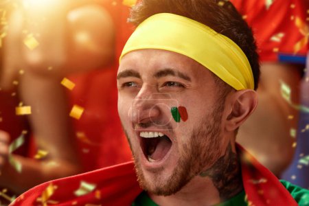 Foto de Imagen de primer plano del hombre, aficionado al fútbol portugal emocionalmente viendo el partido, animando al equipo durante el partido. Concepto de deporte, competición, campeonato, emociones, hobby y entretenimiento - Imagen libre de derechos