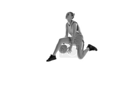 Photo for Black and white image of young athletic girl playing, training basketball against white studio background. Concept of professional sport, hobby, healthy lifestyle, action and motion - Royalty Free Image
