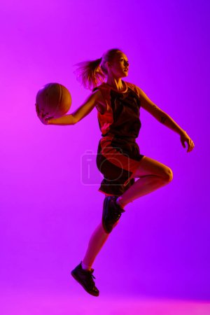 Téléchargez les photos : Image complète de la jeune fille, joueuse de basket-ball en mouvement, jouant sur fond de studio blanc. Un match gagnant. Concept de sport professionnel, passe-temps, mode de vie sain, action et mouvement - en image libre de droit