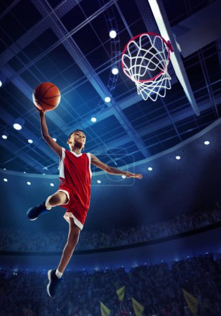 Photo for Dynamic image of little boy, child, basketball player in motion, jumping with ball during match on 3D stadium with flashlights. Championship. Concept of professional sport, competition, action, motion - Royalty Free Image