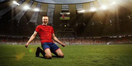 Photo for Young happy man, professional sportsman in red uniform sitting on knees on 3D field with happy emotions after winning championship. Concept of sport, competition, game, emotions, success - Royalty Free Image