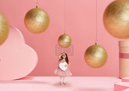 Photo for Merry Christmas and Happy new year. Little beautiful girl, child in cute dress holding present box with happy face over pink background. Concept of holidays, celebration, presents. Copy space for ad - Royalty Free Image