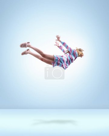 Photo for Having nice dreams. Young girl in colorful pajamas, sleeping mask and slippers flying over light blue background. Concept of fantasy, inner world, dreams, surrealism, creativity, psychology - Royalty Free Image