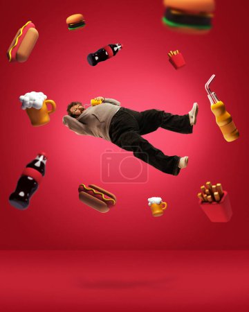 Foto de Adicción alimentaria. collage de arte contemporáneo con hombre adulto con sobrepeso soñando con comida chatarra, cerveza, cola, papa francesa, sándwich, hot dog sobre fondo rojo. Concepto de comida, malos hábitos, adiposidad - Imagen libre de derechos