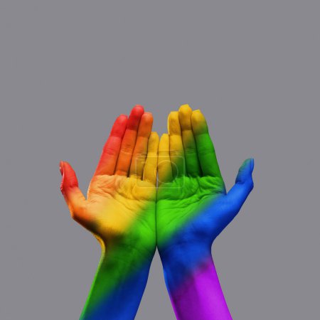 Foto de Manos humanas con palmas abiertas y luces de arco iris sobre fondo gris. Lgbt apoyo comunitario, aceptación. Concepto de libertad, lgbt, elección, relación humana, comunidad, unión, simbolismo - Imagen libre de derechos